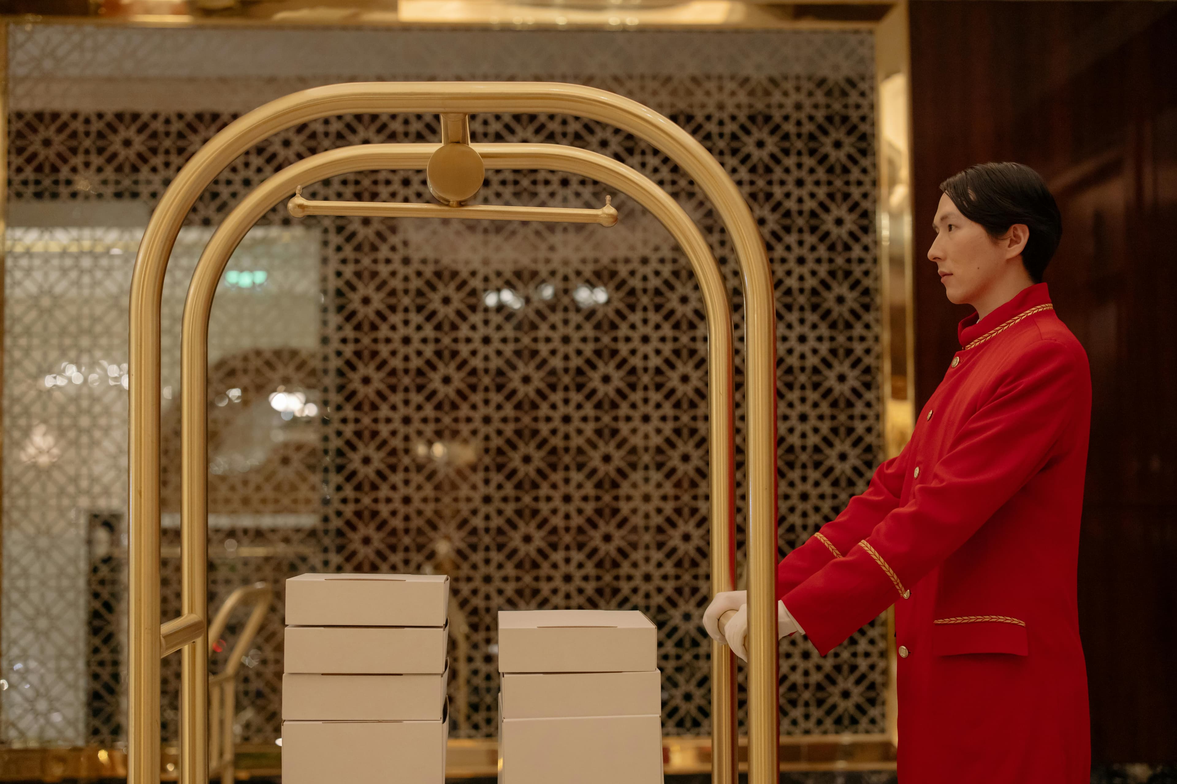 Hotel front desk with staff welcoming guests in a warm, elegant lobby